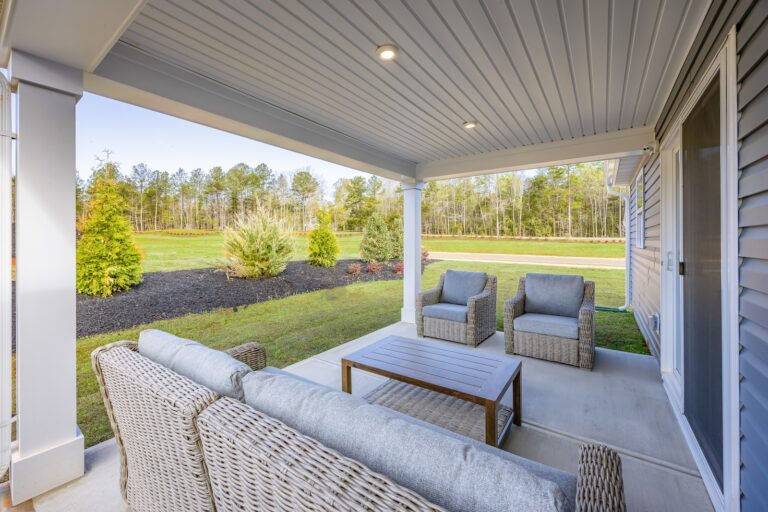 Beautiful Covered Porch with Neutral-Tone Wicker Furniture & Landscaping at Grand Cayman New Home | Pittsburgh New Home Connection